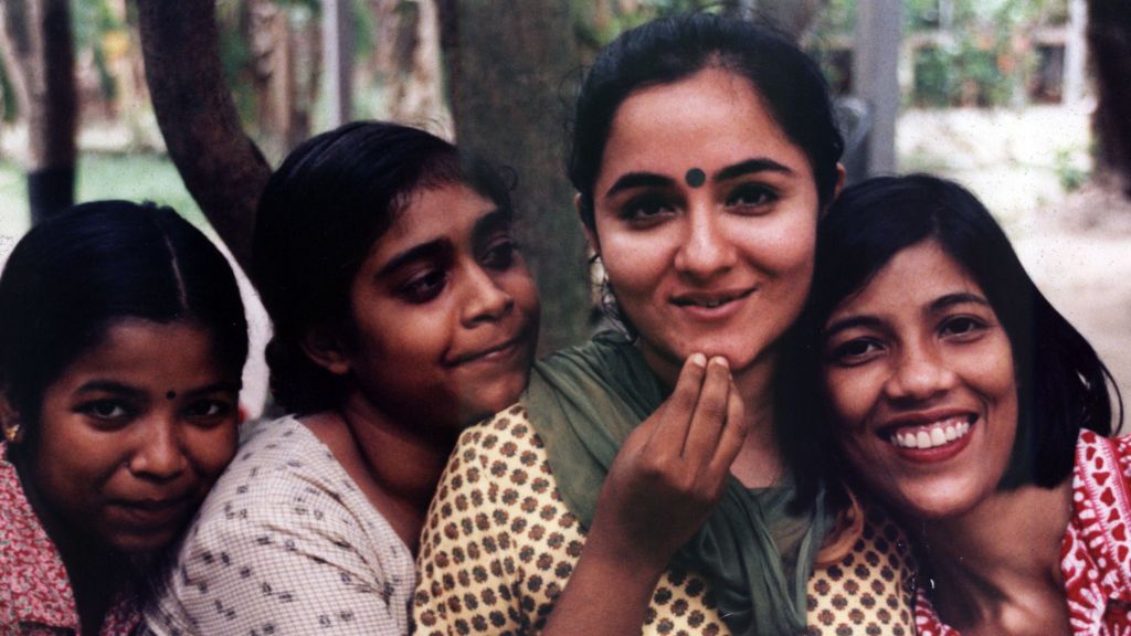 Four Indian women smile for the camera.