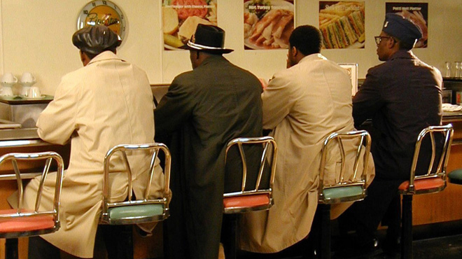 The Greensboro Four sit at a diner counter.