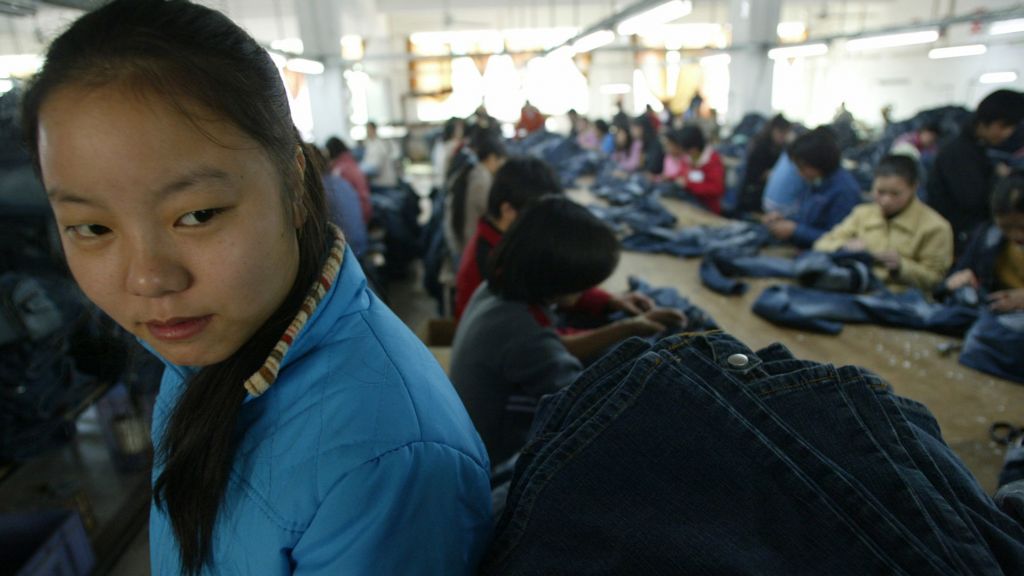 Young Chinese girl in a blue jeans factory.