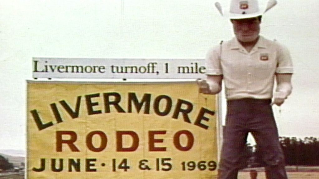 Sign reading Livermore Rodeo June 14 & 15 1969, with an oversized statue of a man in a cowboy hat next to it