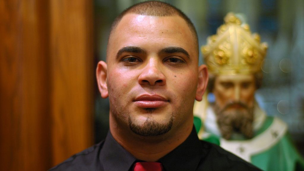 A closeup of a man standing in a Catholic church