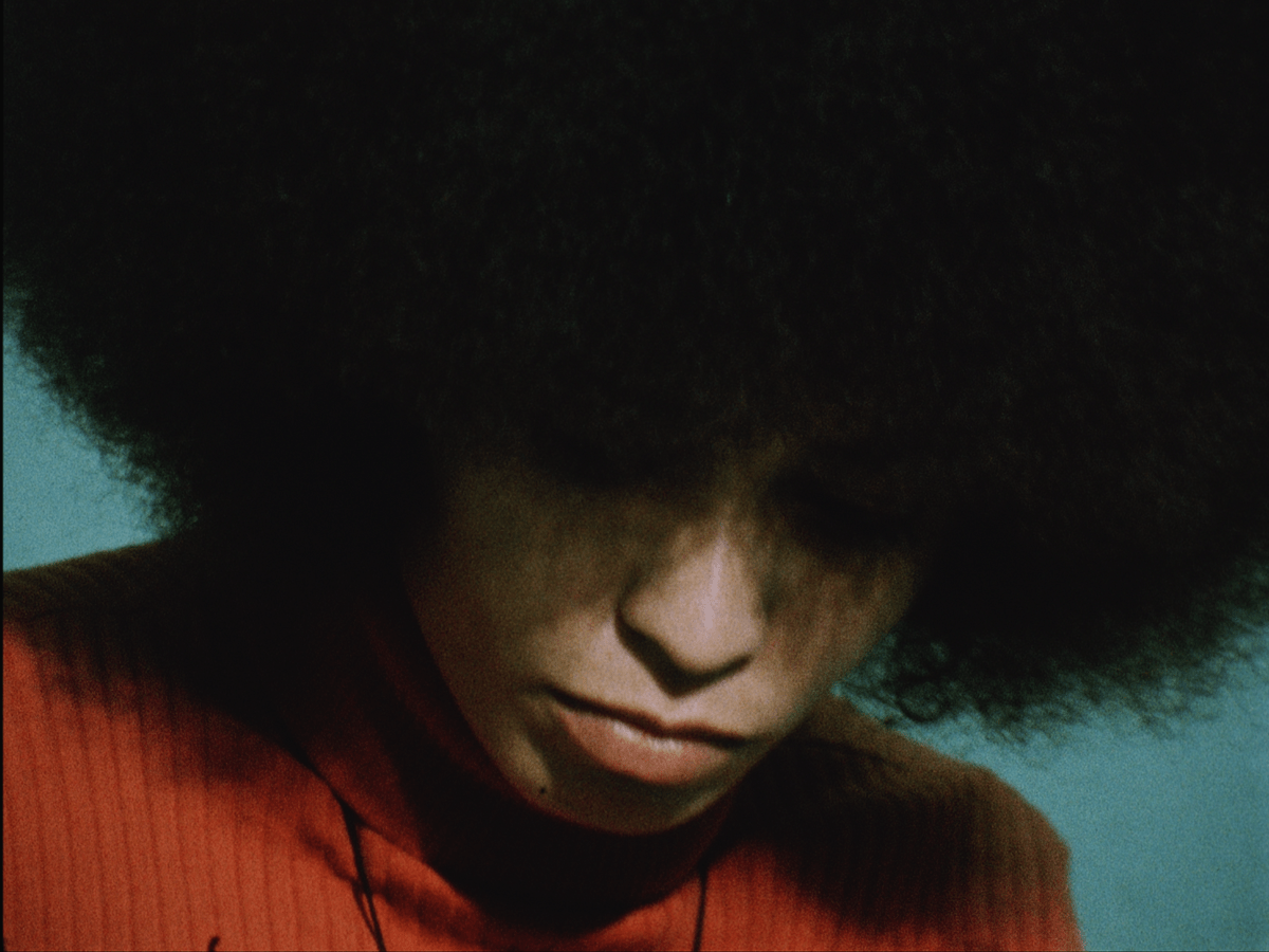 Angela Davis looking down eyes covered by hair