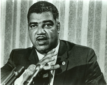 Black and white closeup shot of Whitney Young Jr. at microphone