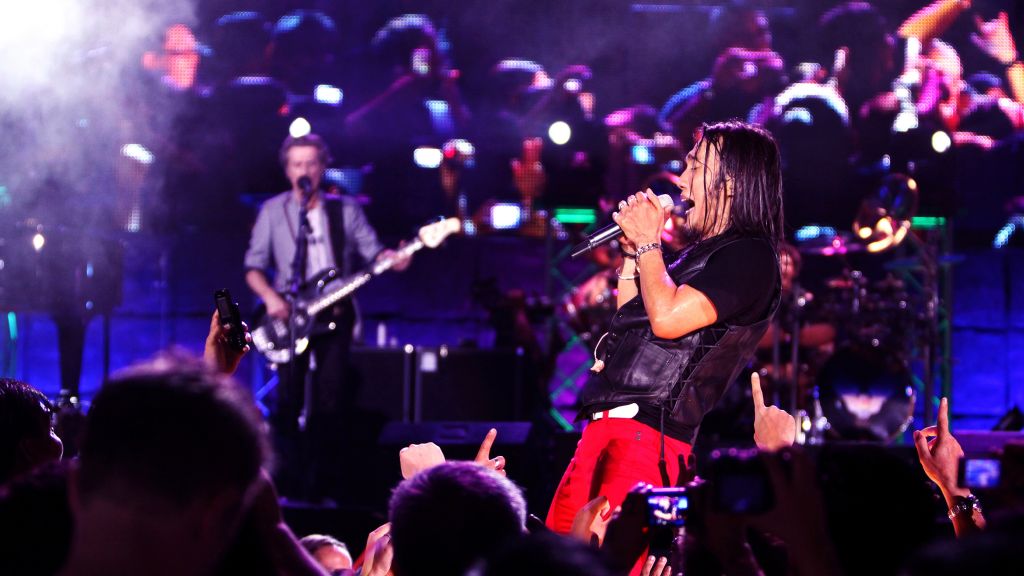 Arnel Pineda sings on stage with rock band Journey.