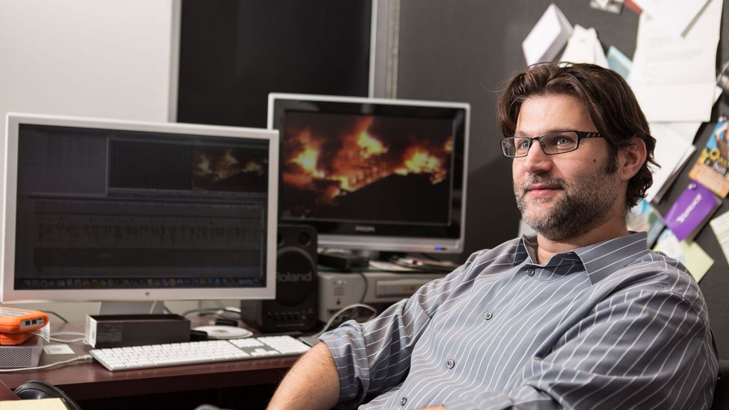 Let the Fire Burn filmmaker Jason Osder sitting in the edit suite