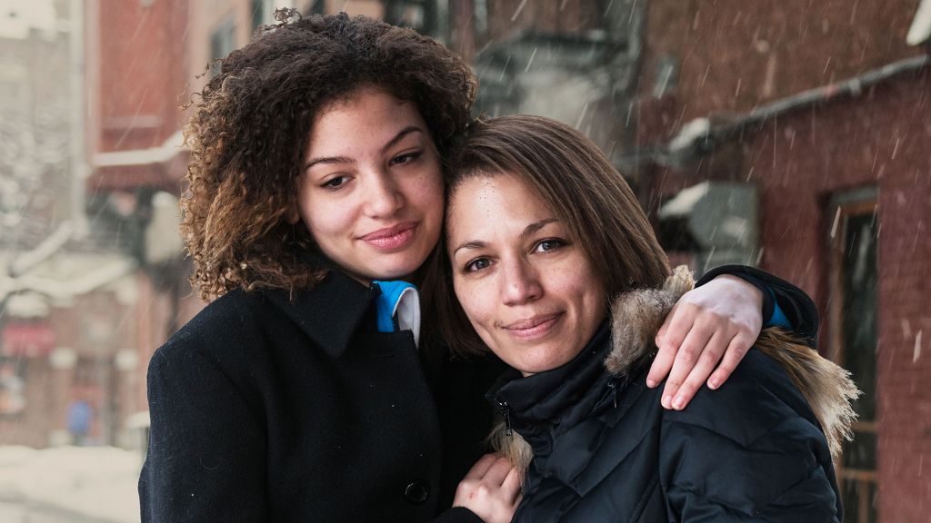 A teen girl embraces her mother.