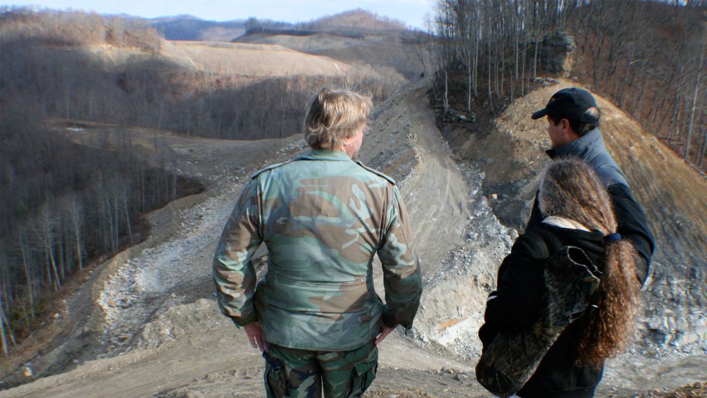 Three people survey a quarry in Appalachia.