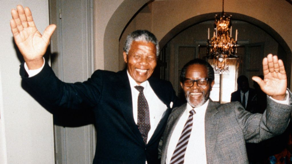 Neslon Mandela and Oliver Tambo smile and wave.