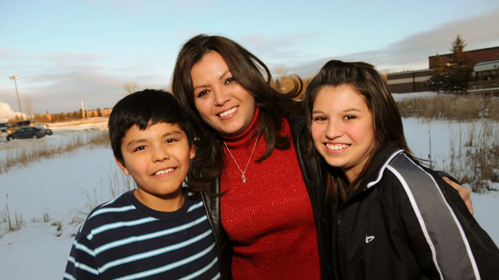 Robin Charboneau, an Oglala Sioux mother poses, smiling, with her son an daughter.