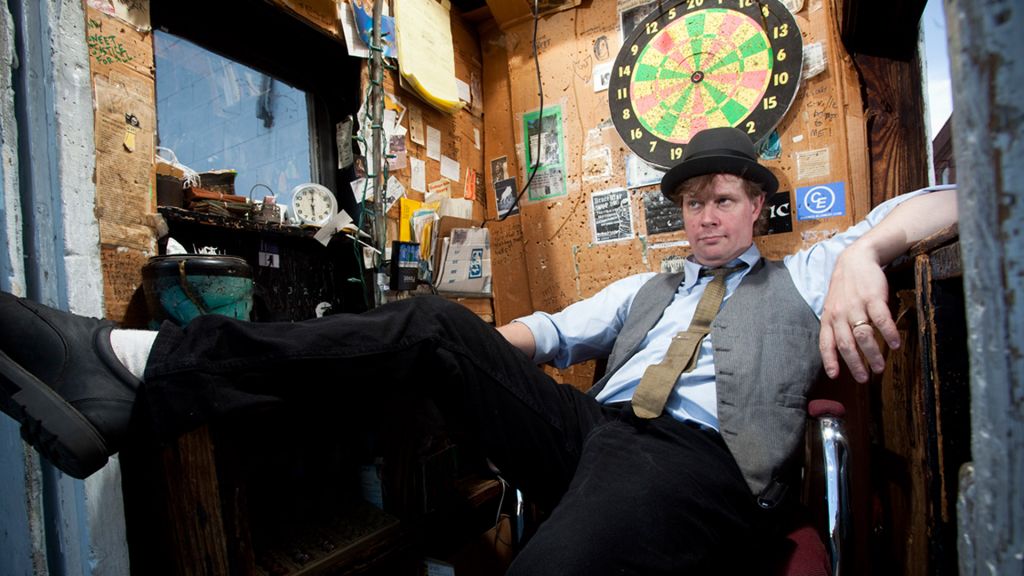 A parking attendant reclines in his booth.