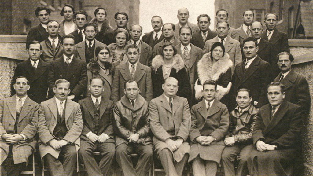 A group of men and women in the 1920s pose for the camera