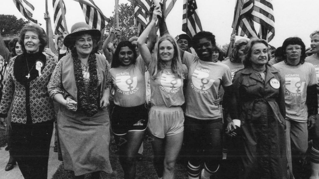 Women march holding American flags