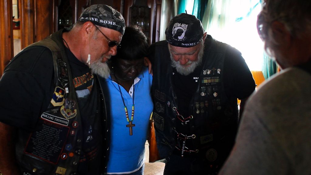 Ron "Stray Dog" Hall takes a moment of prayer with fellow vets and the mother of a fallen soldier