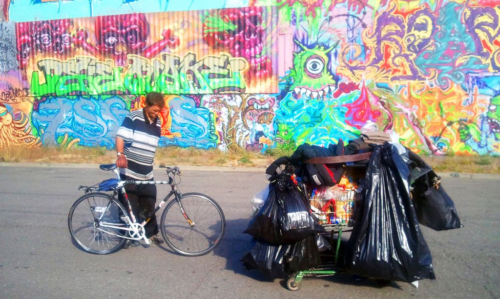 From Dogtown Redemption: A recycler named Jason takes a break from hauling with his bicycle and cart.