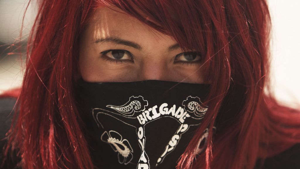 Masked member of Ovarian Psycos bike brigade