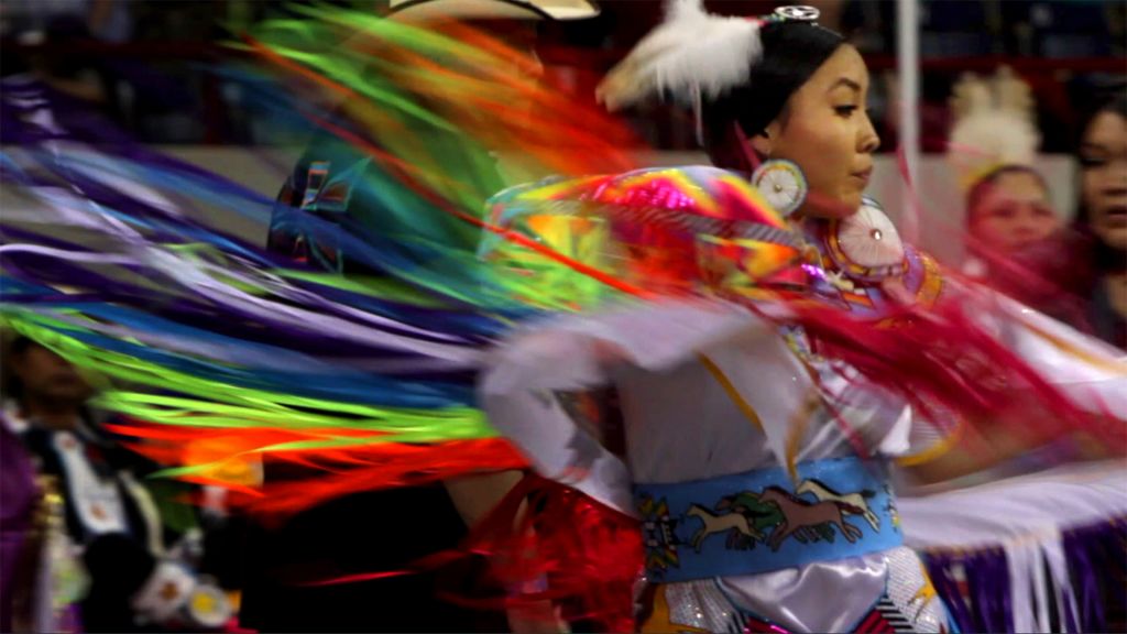 Native American woman in head dress dancing