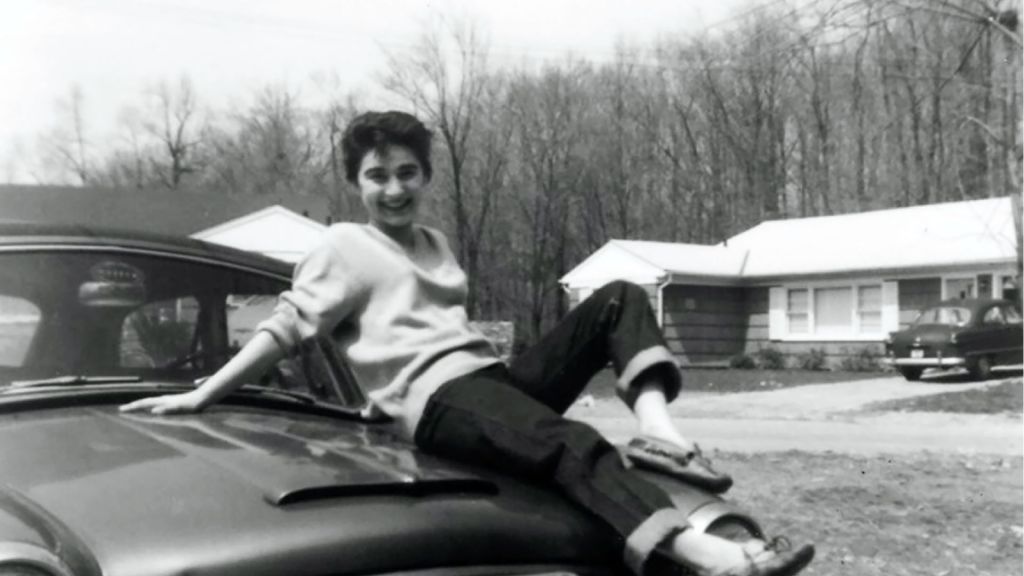 Kitty Genovese atop a car in black and white photo, circa 1956. Photo Courtesy June Murley.