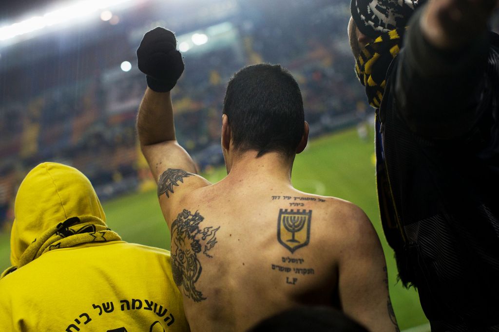 From Forever Pure, a dedicated Beitar FC fan with back to camera, tattooed