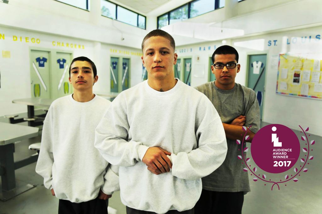 They Call Us Monsters trio of youths in juvenile pen posing for the camera; with Audience Award graphic added