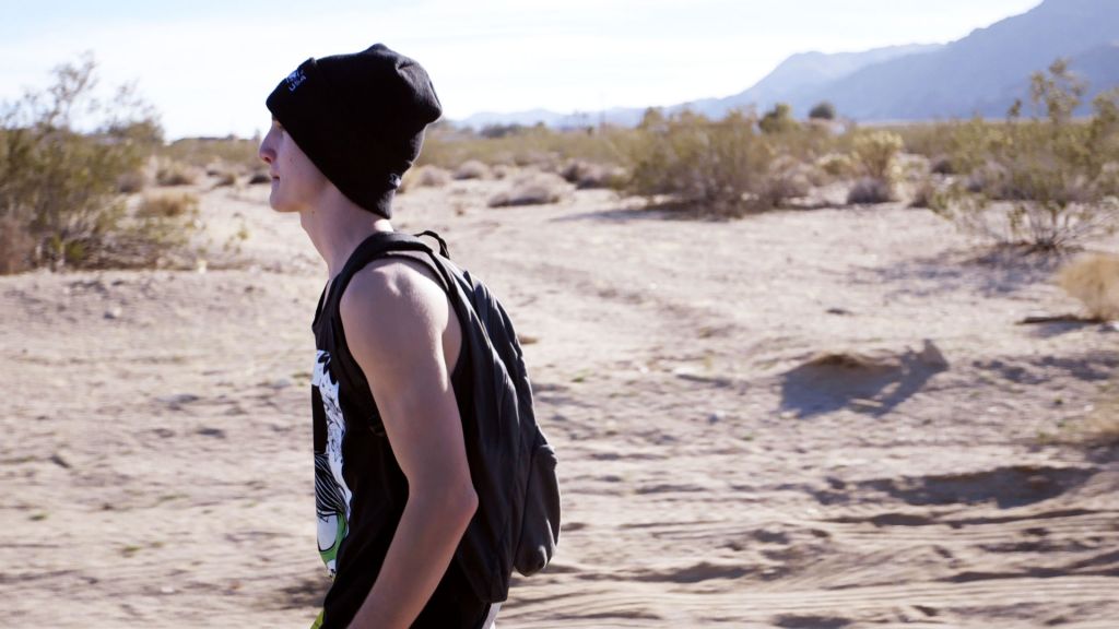 Joey McGee walks down a road in the Mojave Desert.