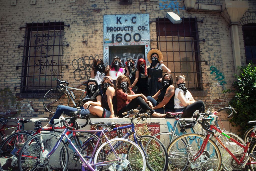 The Ovas bike brigade pose with bikes in front of a warehouse in East Los Angeles