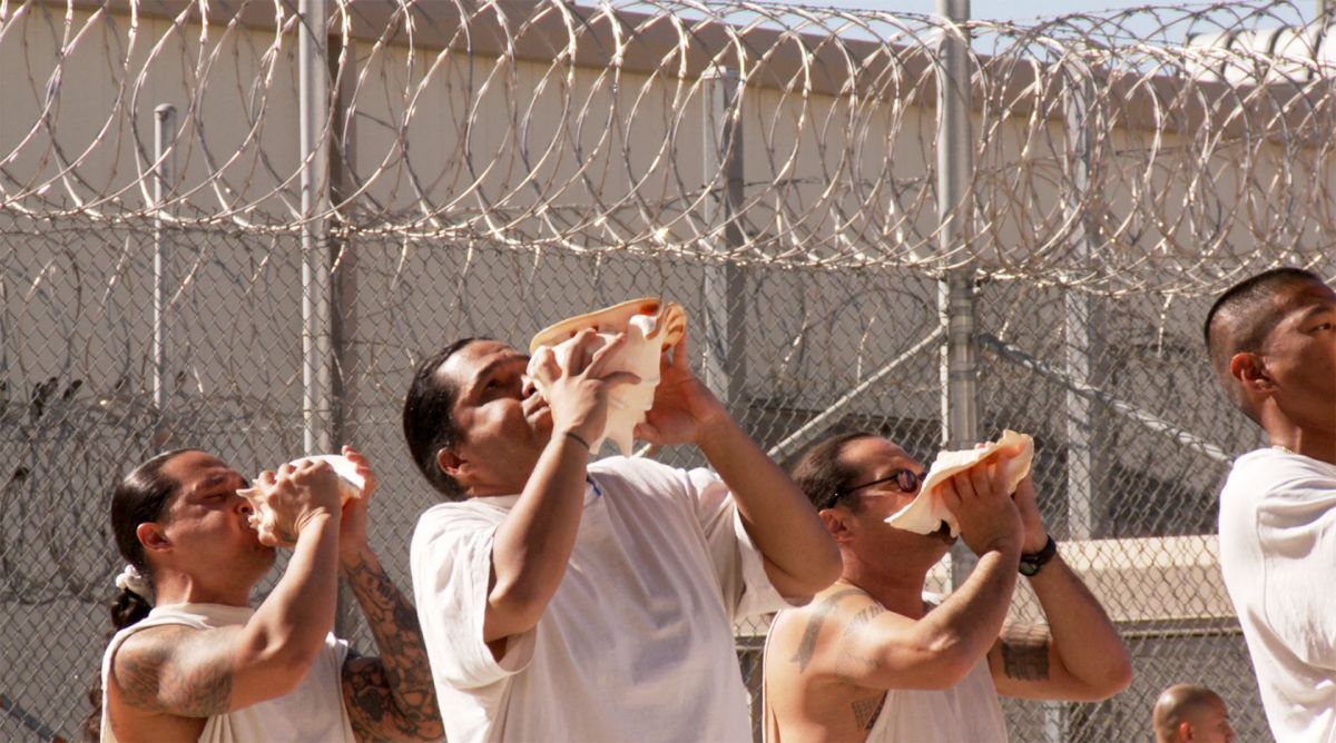 Native Hawaiian prisoners perform a ritual ceremony using conch shells as instruments