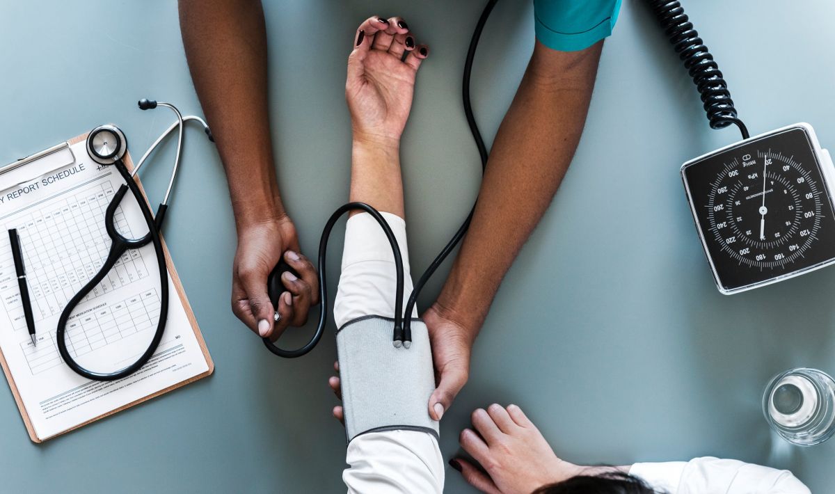 doctor takes a patient's blood pressure; image courtesy Rawpixel.com