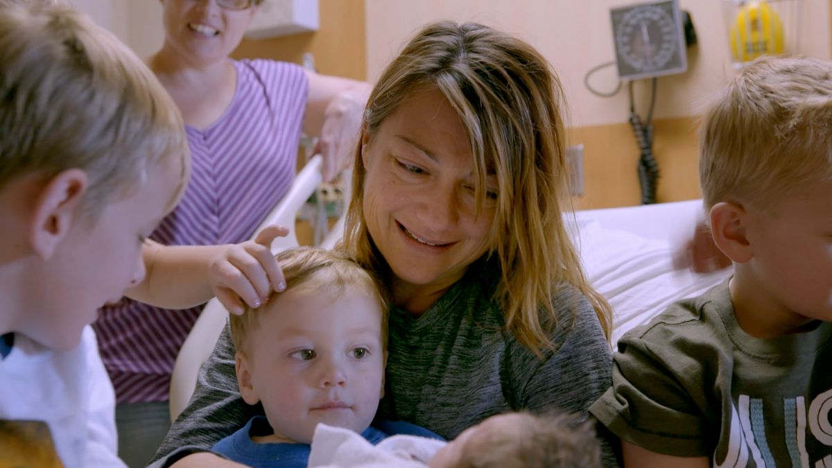 Cindy and family hold baby.