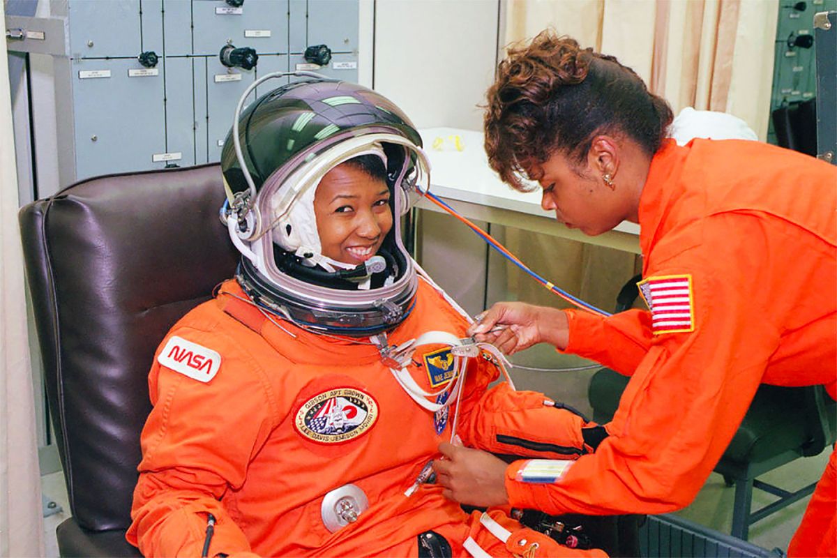 NASA astronaut Mae Jemison waits as her suit technician, Sharon McDougle, performs a unpressurized and pressurized leak check on her spacesuit, 1992.