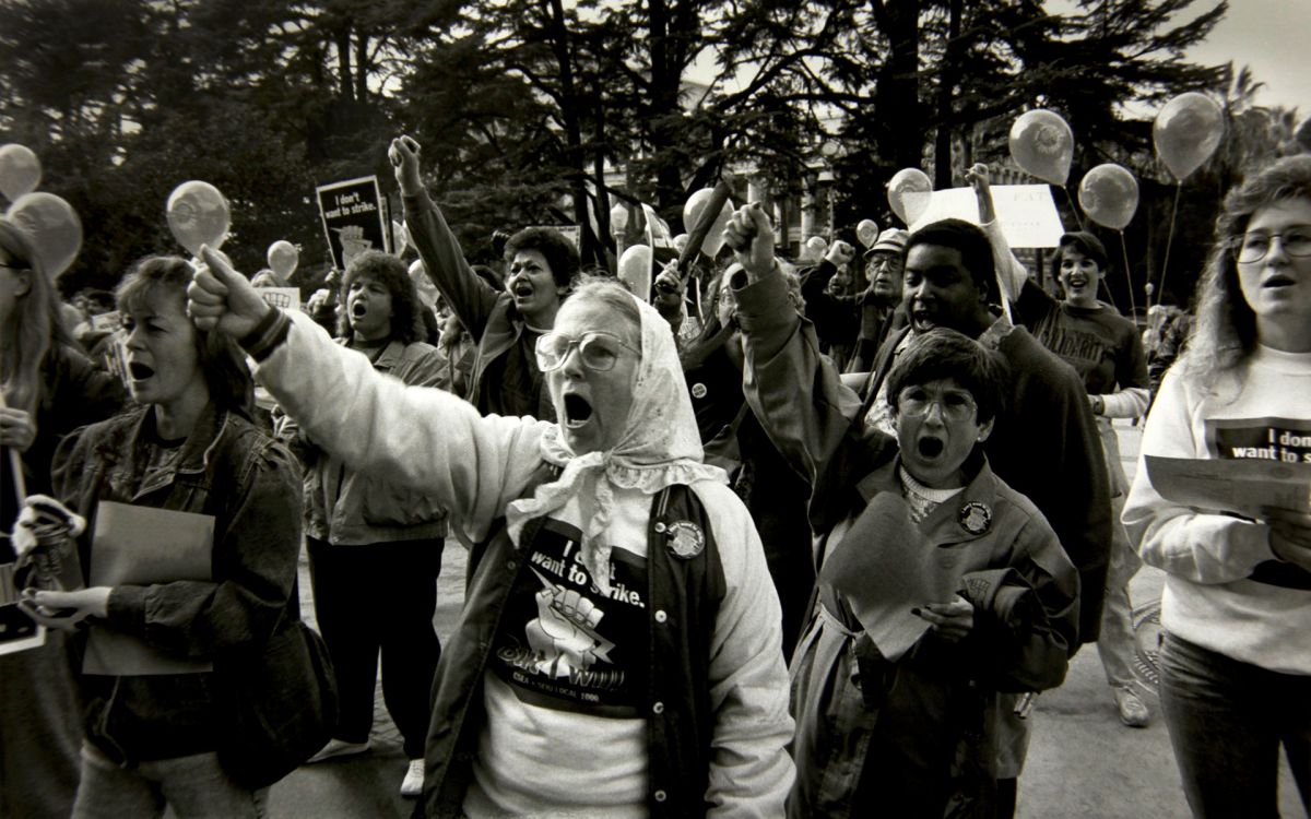 Black and white photograph of a large group of women protesting at a rally for equal pay.