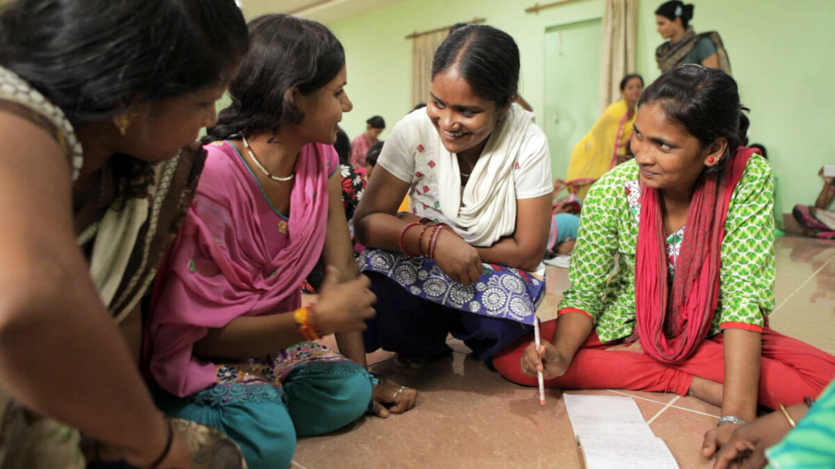 Four Indian women reporters chat together while working on a project.