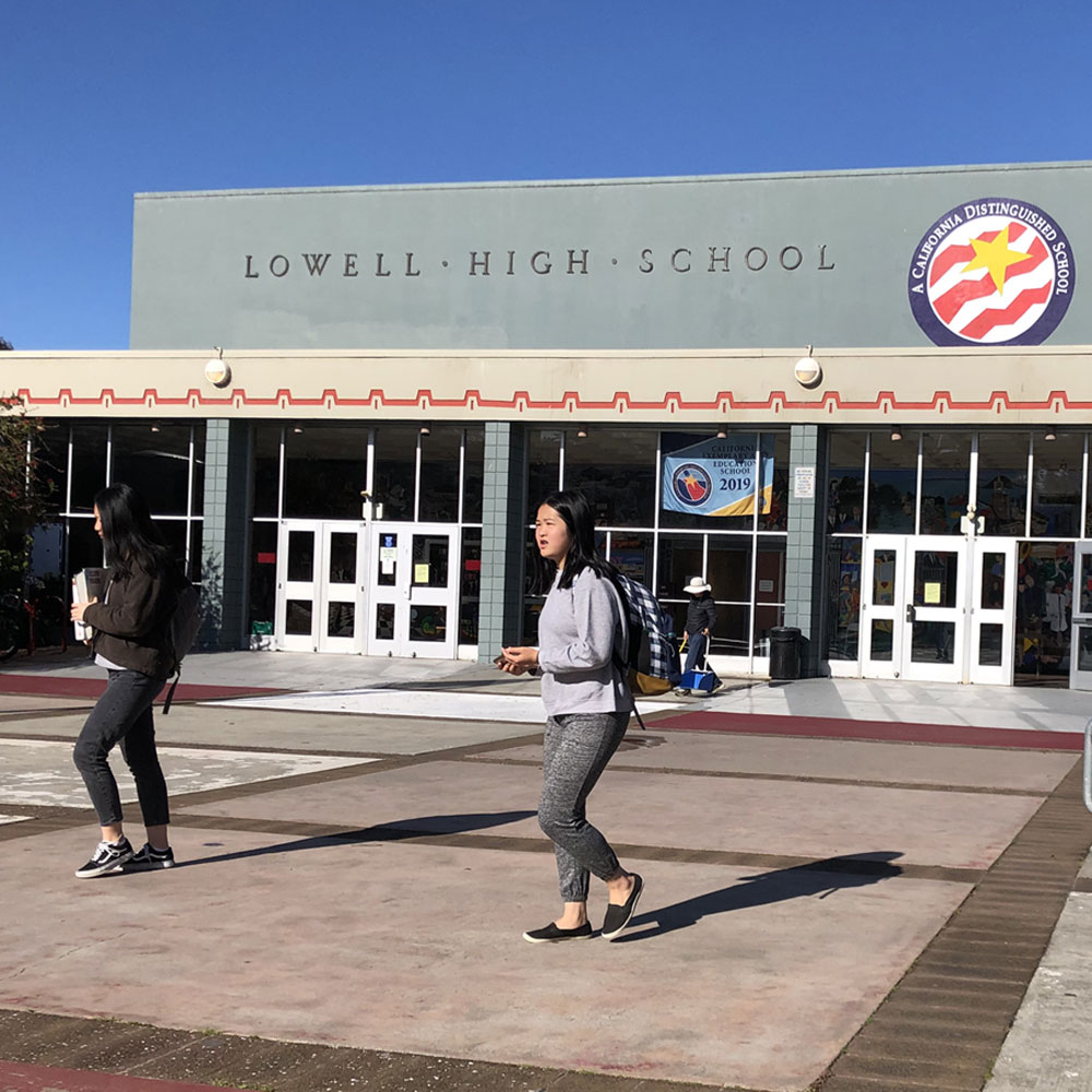 Students walk outside the entrance to Lowell High School.