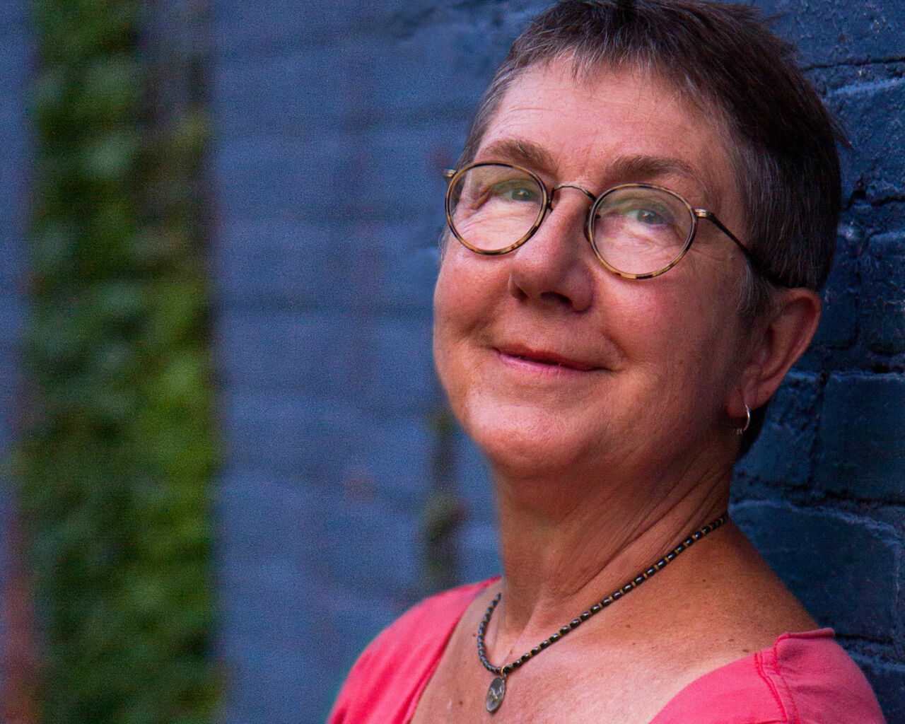 Headshot of filmmaker Julia Reichert, a smiling woman with light skin tone, short hair and glasses.