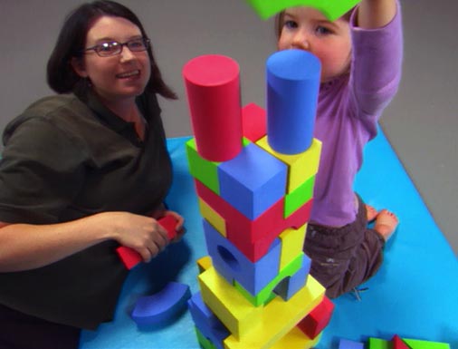 Woman and child build tower