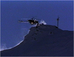 Researcher at tower high in Alps being picked up by helicopter