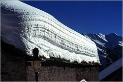 Layers visible in snow on cabin roof